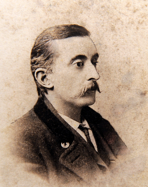 Sepia photograph of Lafcadio Hearn in formal Victorian attire, showcasing the Greek-Irish writer during his time in America before moving to Japan